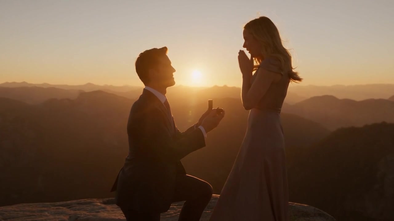 Une demande en mariage au sommet d'une montagne, au coucher du soleil