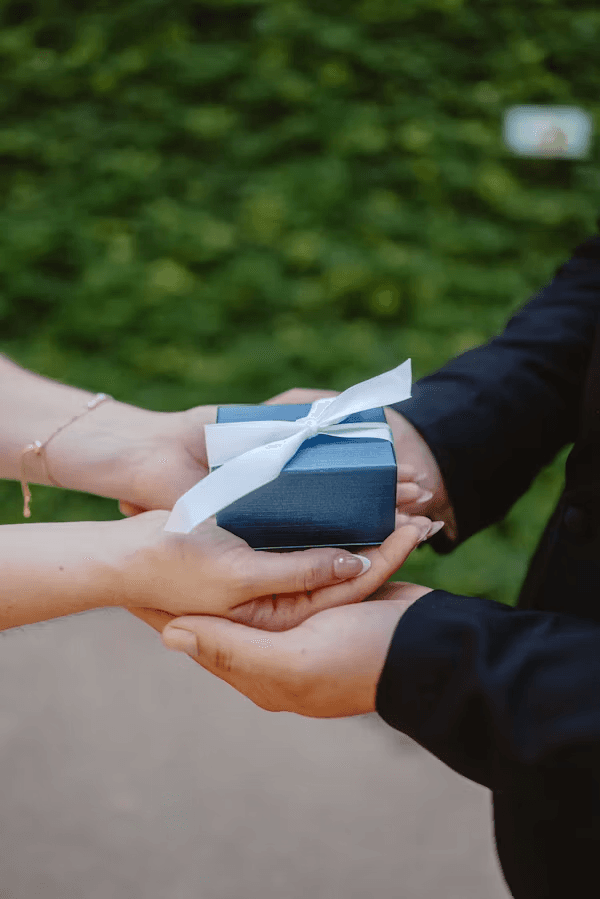 Un invité remettant un cadeau emballé aux mariés